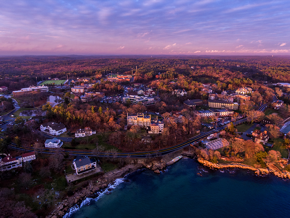 aerial shot of campus from over ocean during sunset