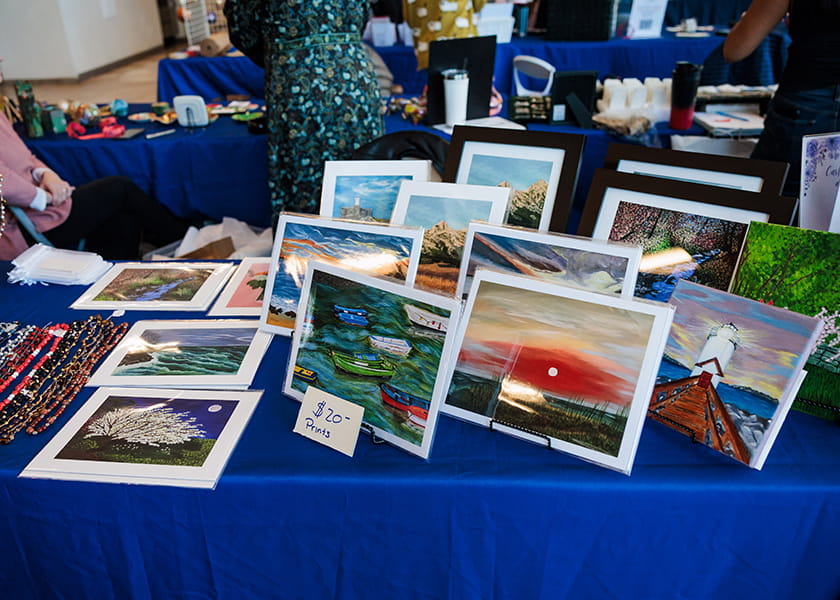 Small art prints and beaded jewelry displayed on a table.