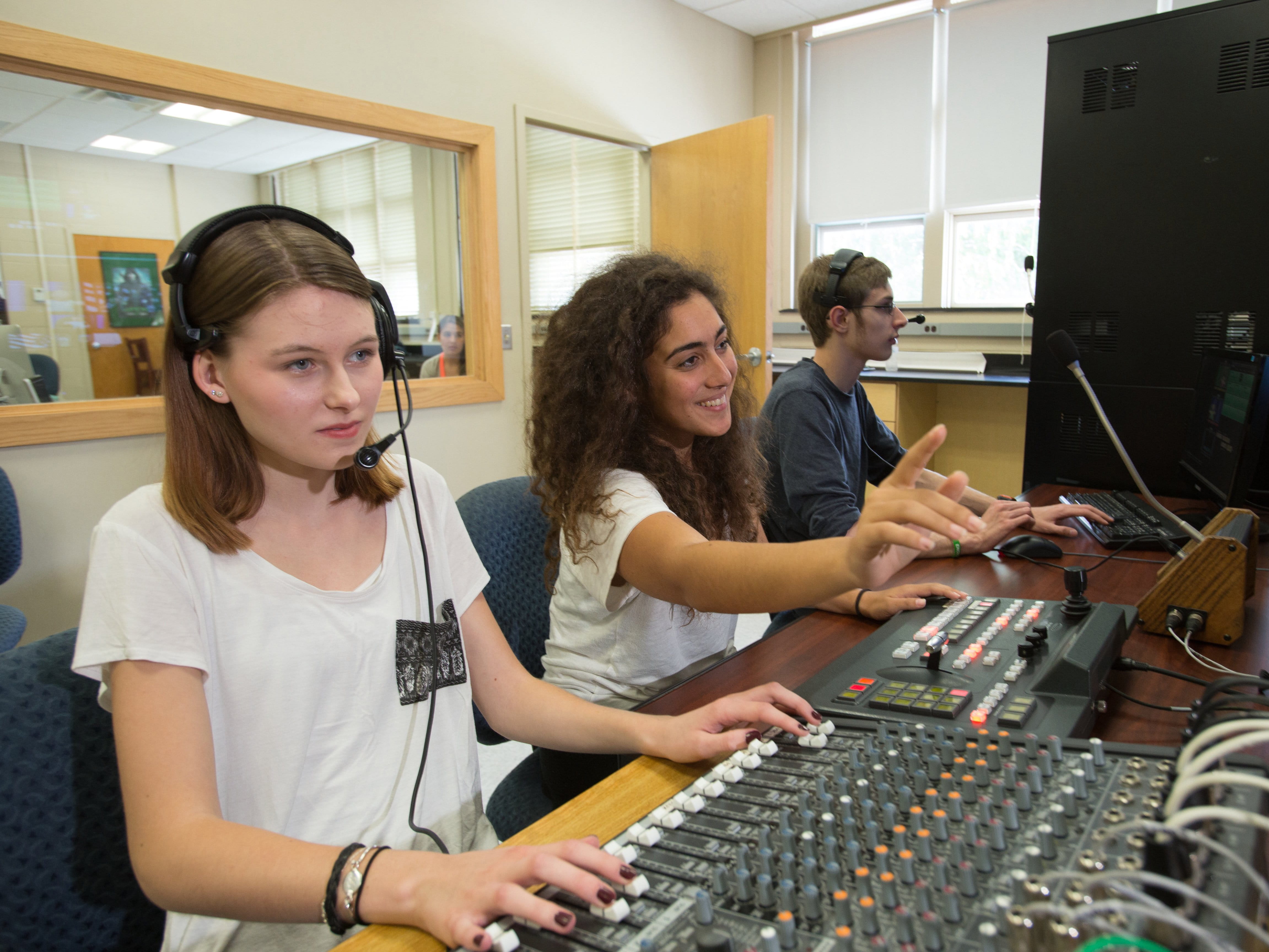 students working in sound booth with headphones