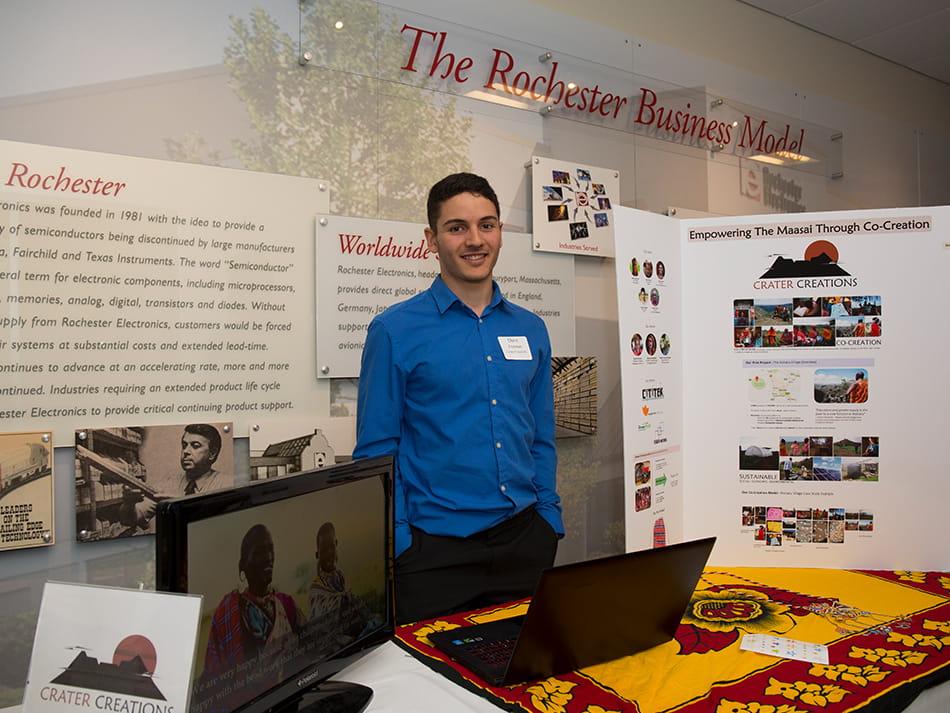 a guy presenting a booth about the rochester business model