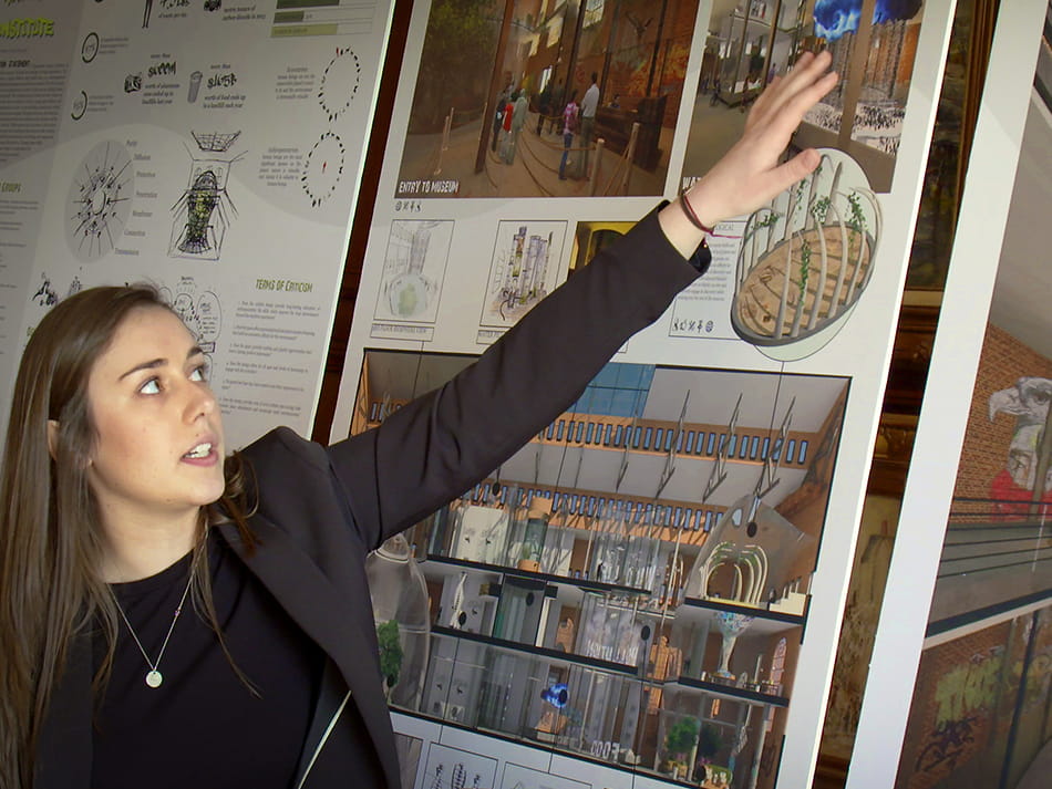 a woman pointing and explaining the interior design works on the wall 