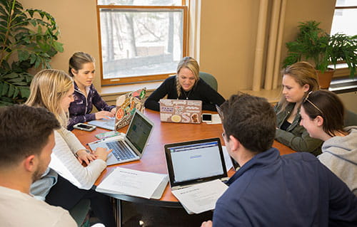Students with laptops working around a table
