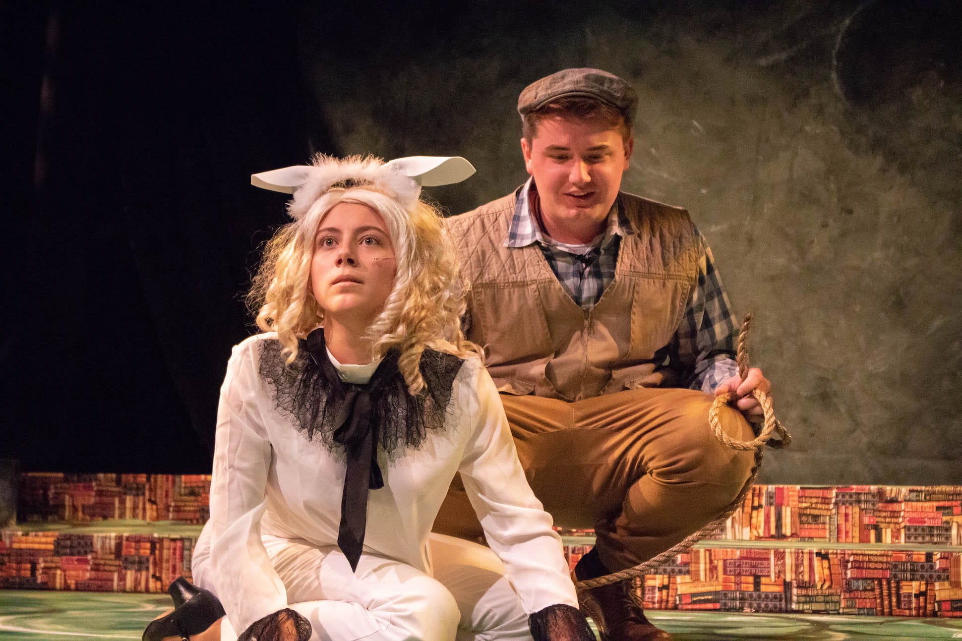 Two actors crouched dressed up in costumes during play one as dog one as male dog owner