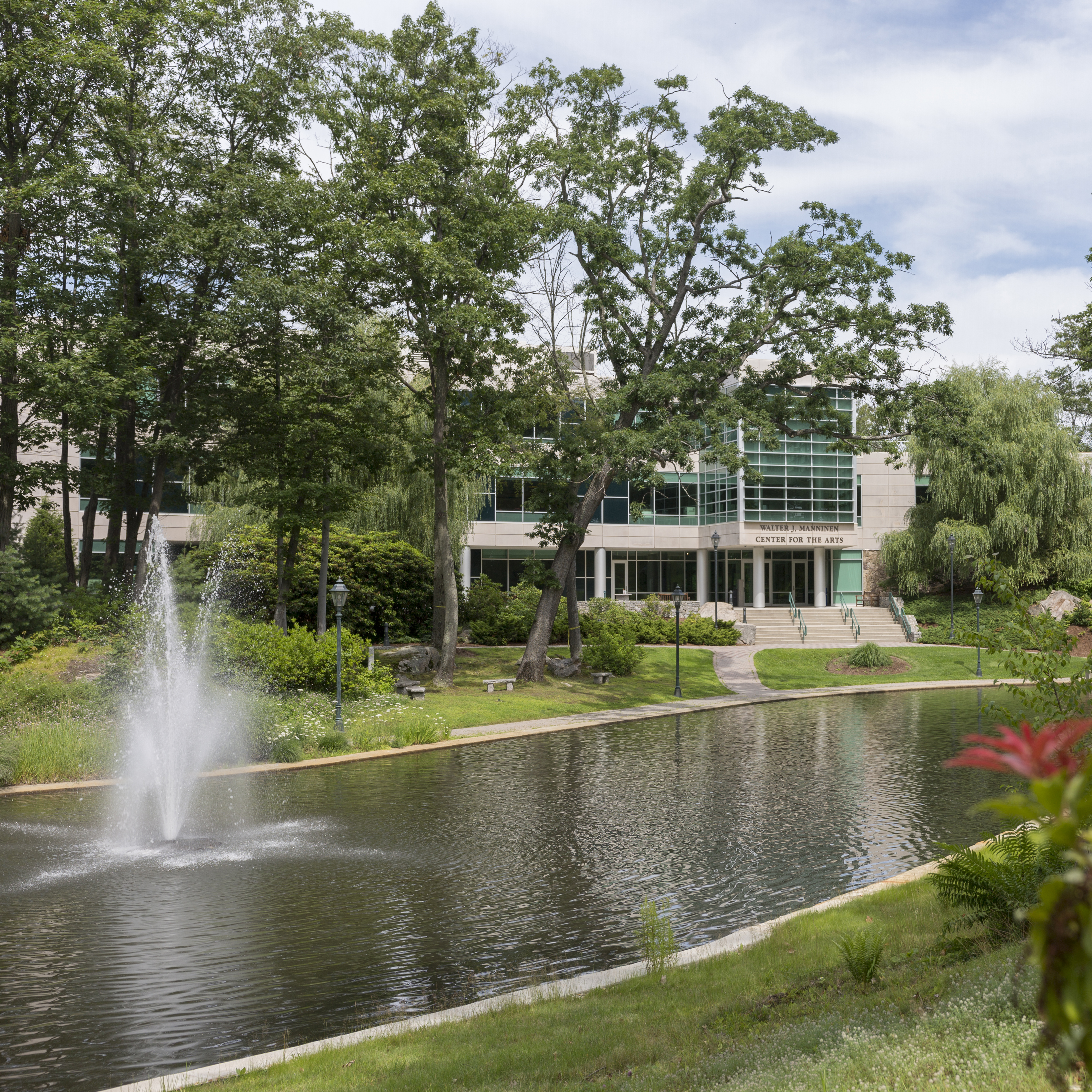 shot of pond with manninen arts center in background