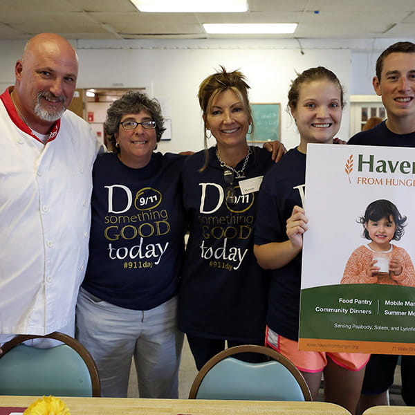 a chef and four others posing for a photo with a 'Haven from Hunger' sign