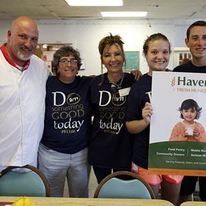 a chef and four others posing for a photo with a 'Haven from Hunger' sign