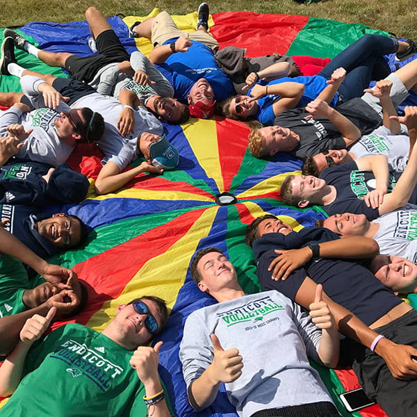 a group of people laying on a multicolored circular sheet