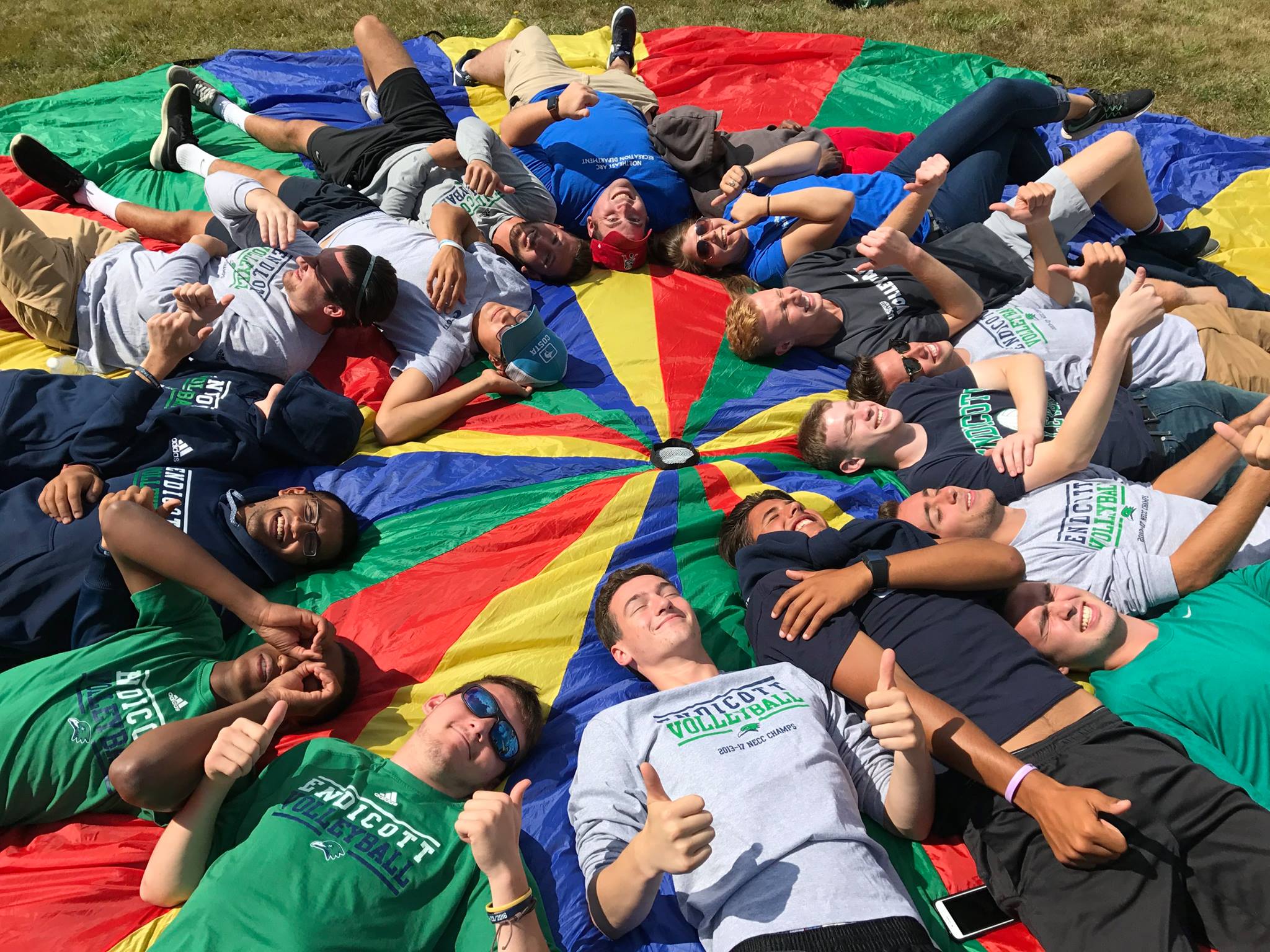 a group of people laying on a multicolored circular sheet