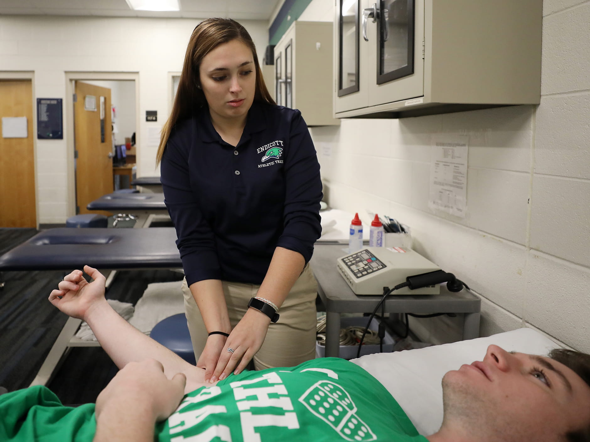 Jennifer Holman '18 works with an athlete in Endicott's athletic training room. 