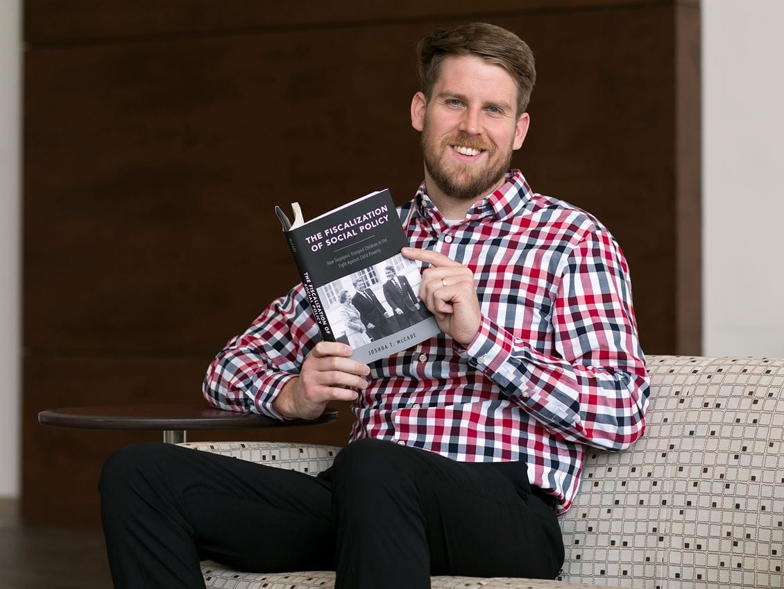 Joshua McCabe holding his first book. 