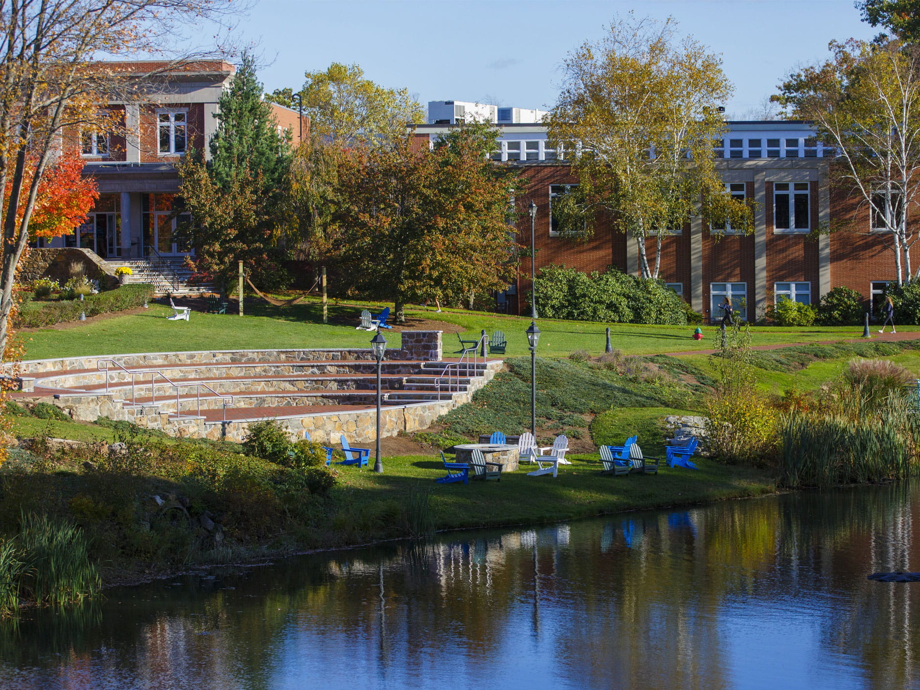 Photo of outdoor ampitheater with library in the background and fall foliage 