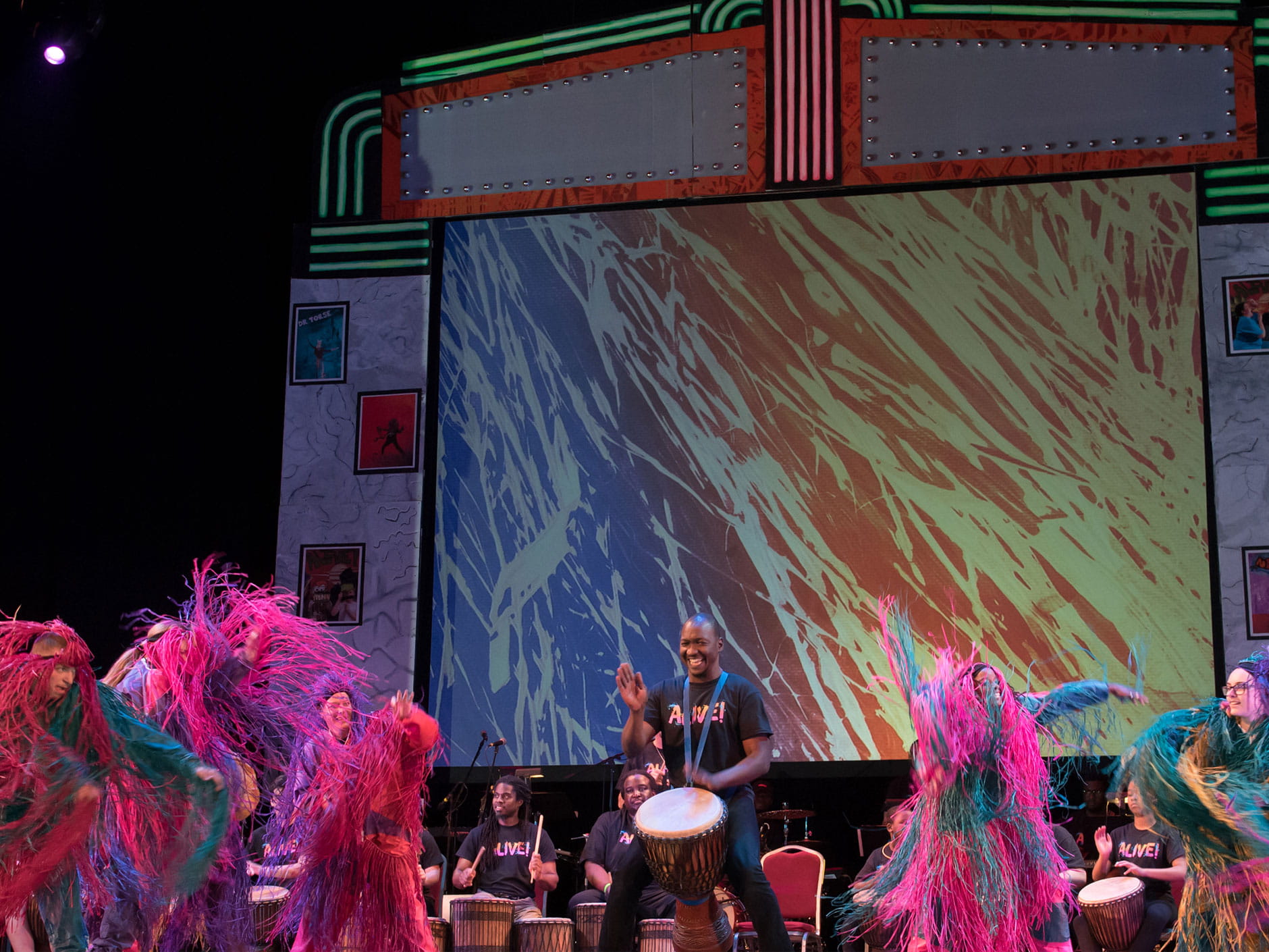 Express Yourself dancers in colorful costumes join musicians on a decorated stage