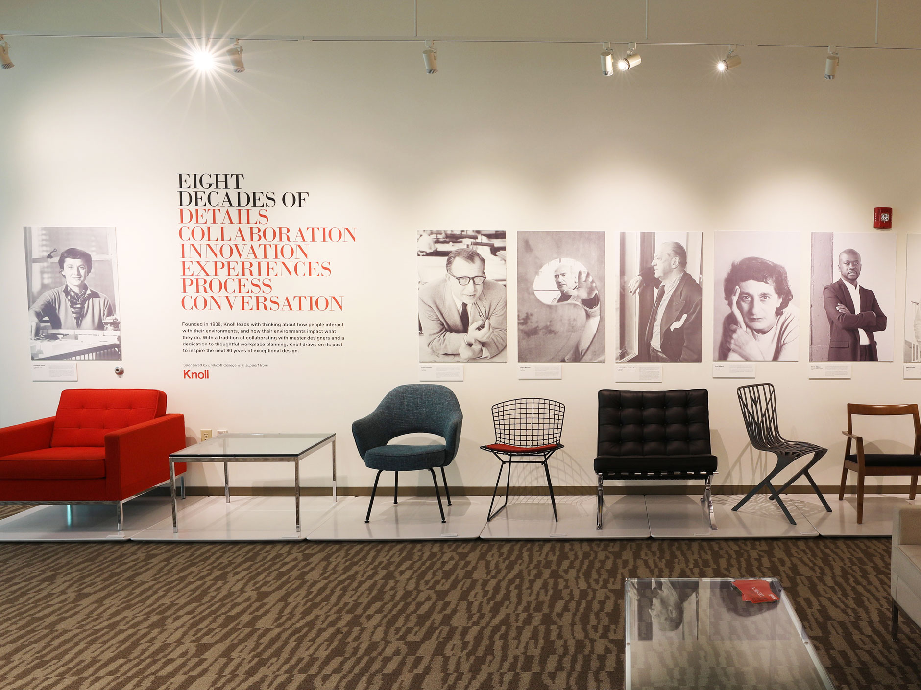 Image shows a line of chairs and images as part of the exhibit on Knoll furniture and design
