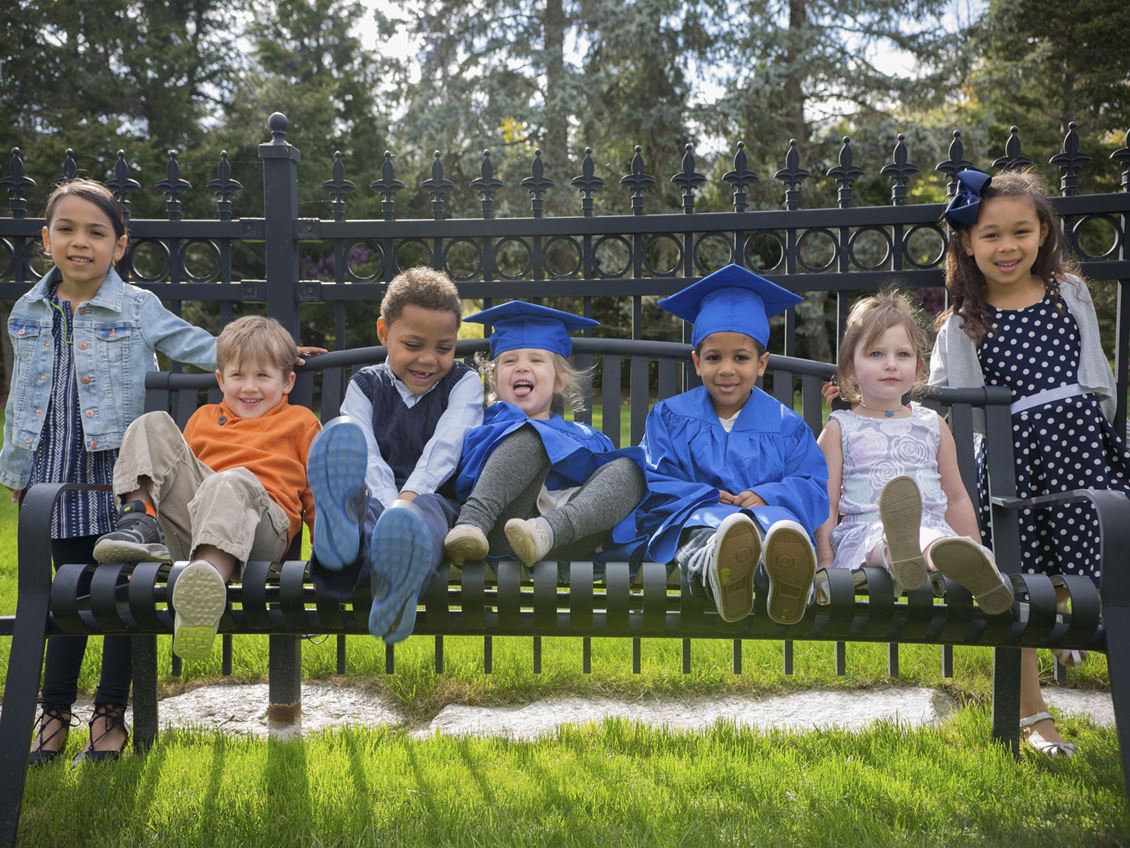 Young children sit on a bench 