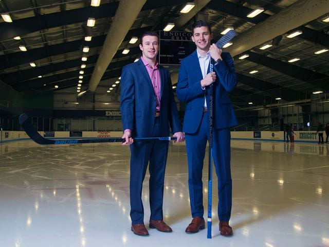 Carter Horowitz and Michael Heidkamp dressed in suits on the ice