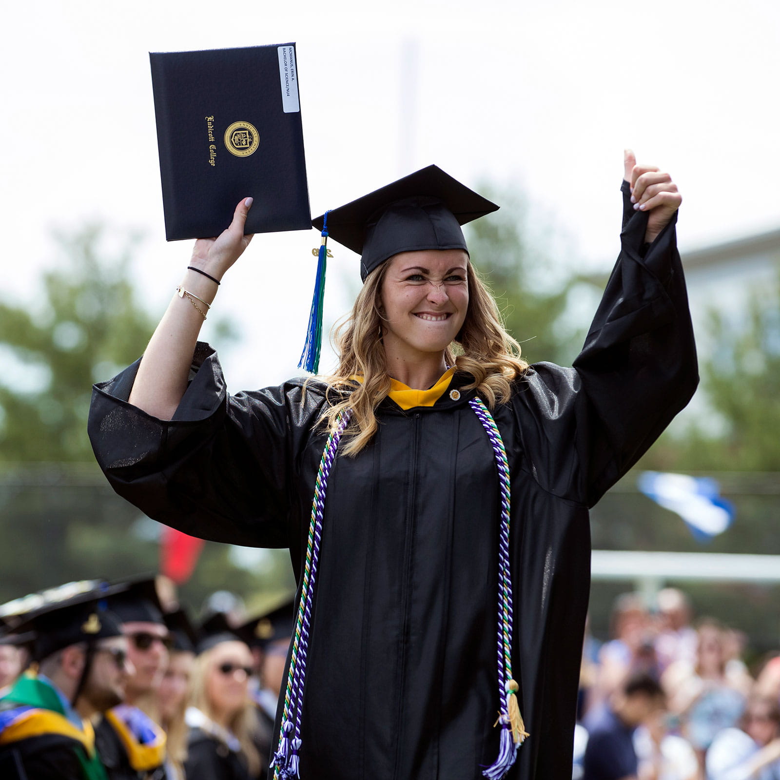 Graduate holding up diploma