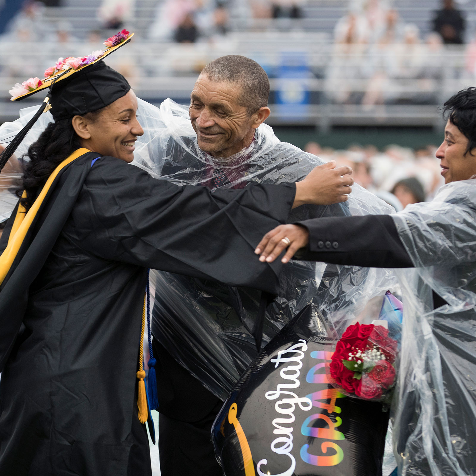 Graduate hugging family 