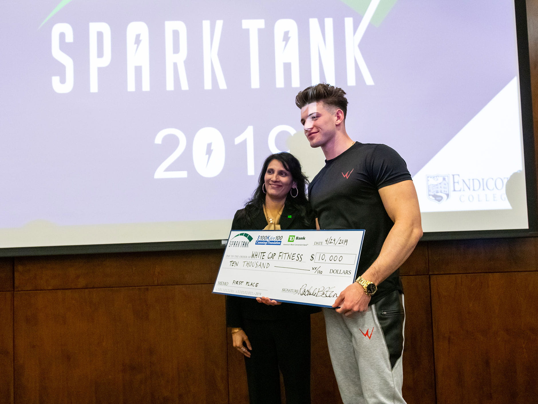 Winner of 2019 Spark Tank stands with check. 