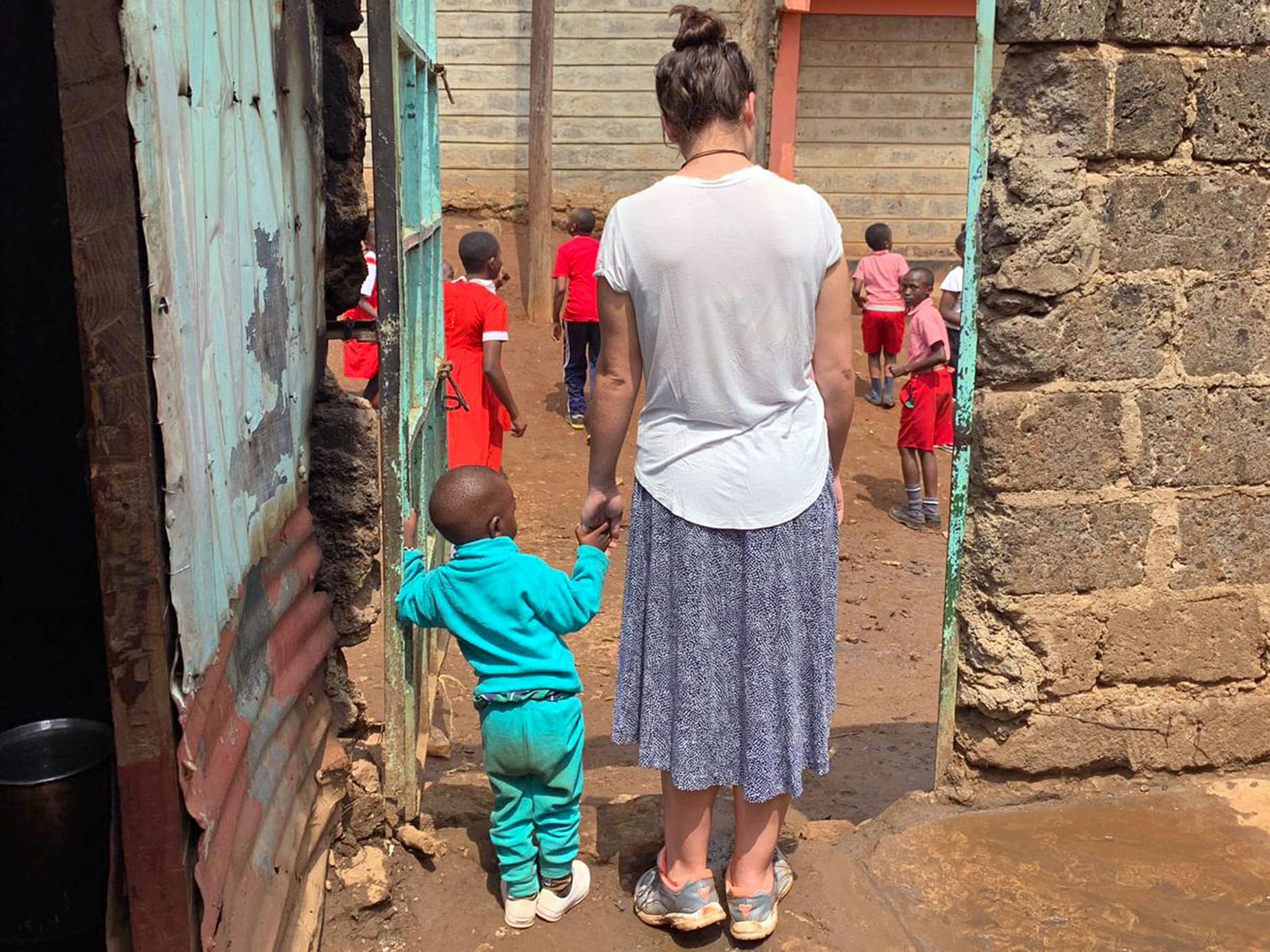 Emma Roca '21 holding a young child's hand at an orphanage in Africa