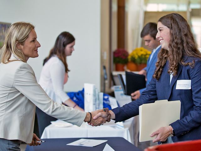 Lindsay Campbell (right) shaking hands with a recruiter at Meet the Firms