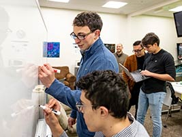 students work to develop application on whiteboard inn classroom