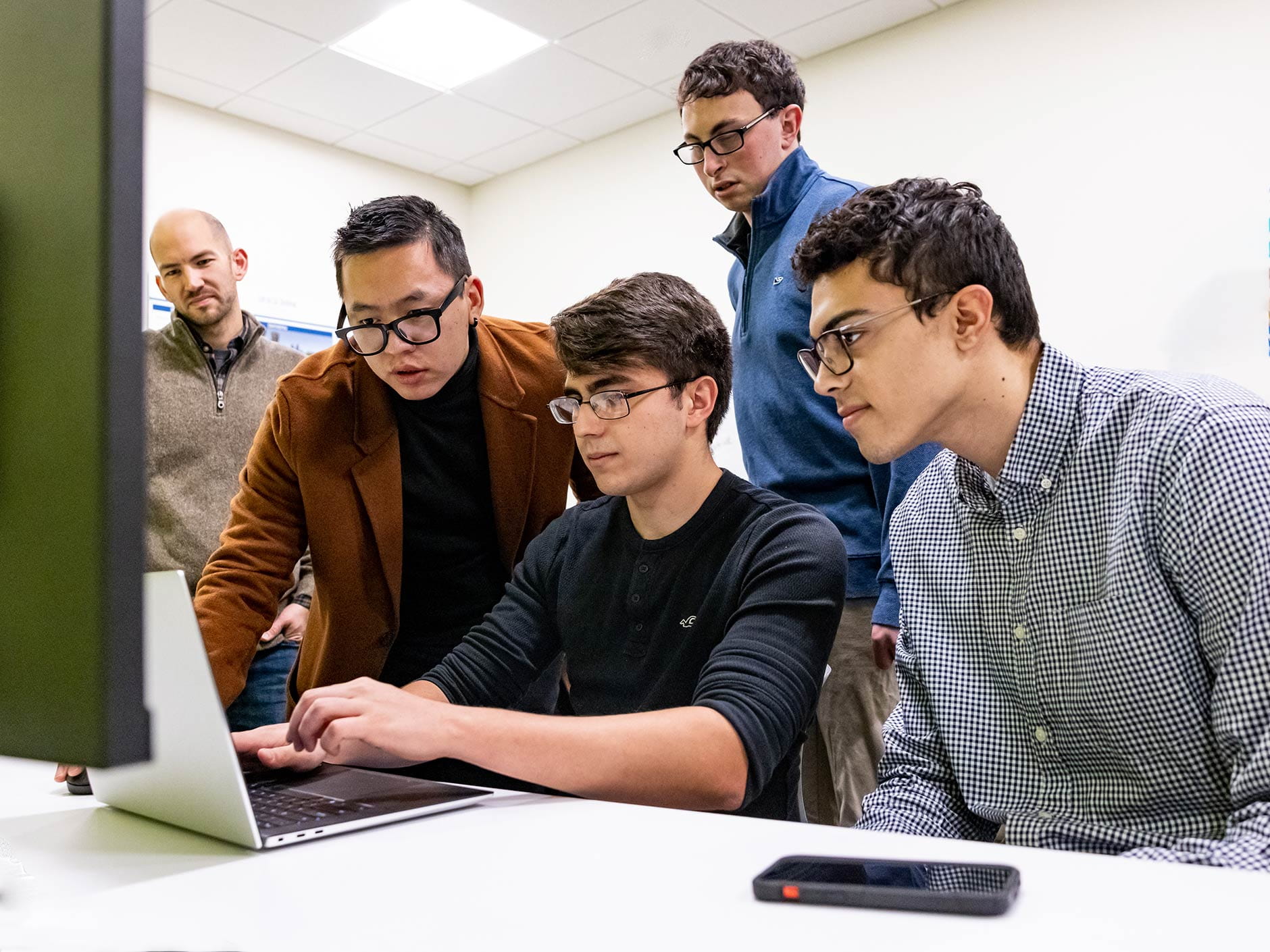 Developers of the Alive Application sit at desk and laptop for their work