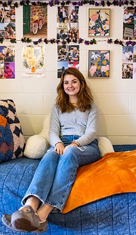 nesting article endicott girl on bed in front of photo wall