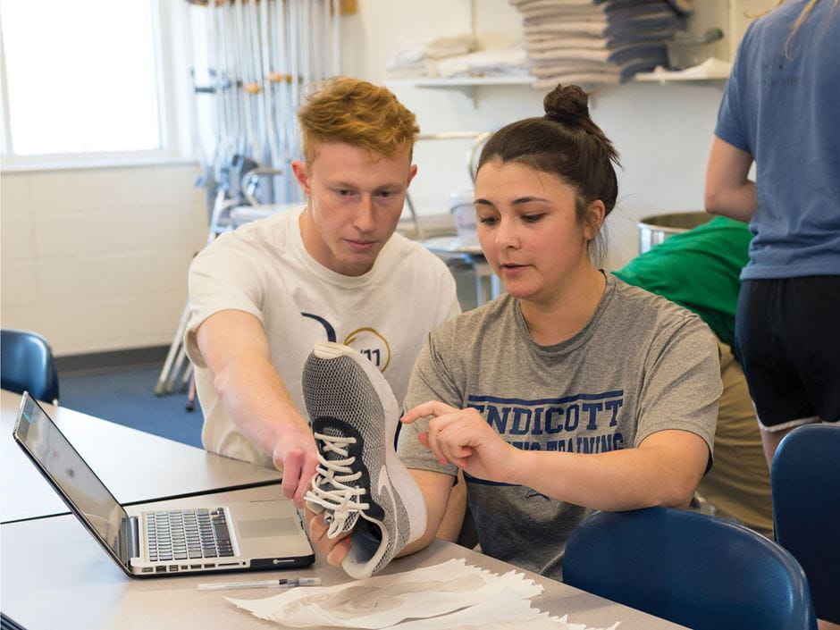 Athletic trainers holding a shoe