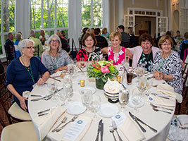 Alumni gathered around a table at Tupper Manor