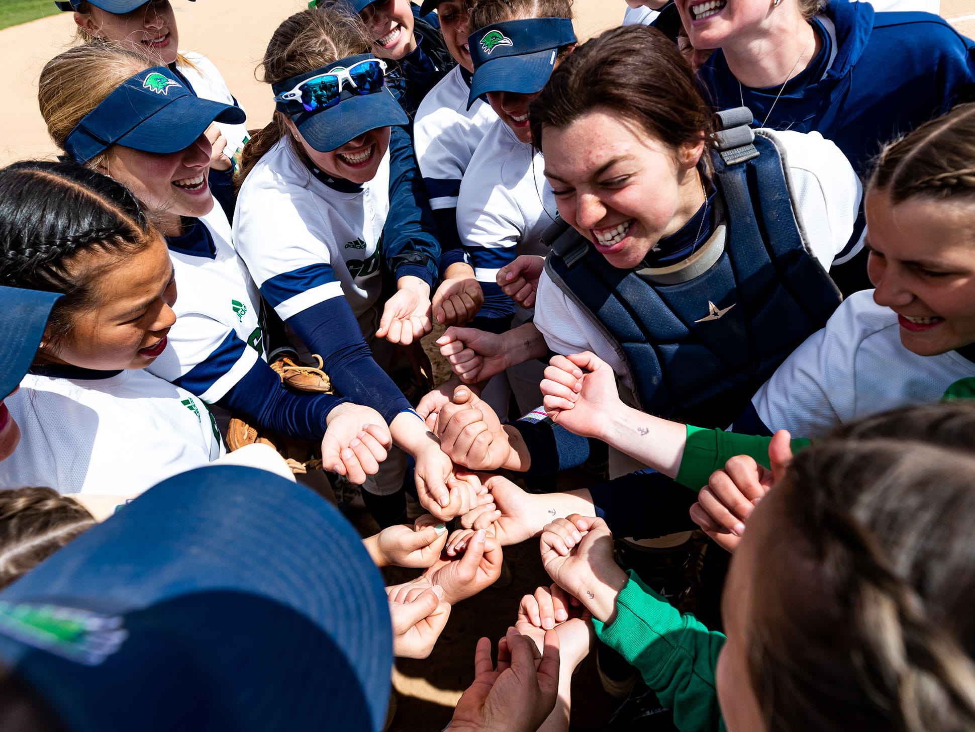 The softball team gets amped up before their Commonwealth Coast Conference Championship game against Western New England University.