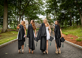 Endicott Class of 2020 graduates Katherine Longworth, Casey Monahan, Araya Lessard, and Alexandra O'Brien walk toward College Hall