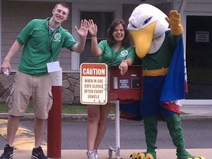 two people standing with endicott gull mascot outside of campus safety building