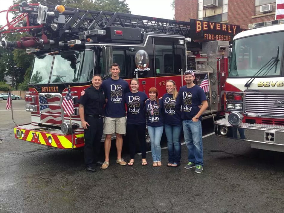 students taking a picture in front of a fire engine at local fire house