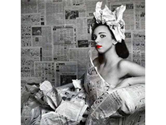 a woman sitting in a dressed made from newspapers