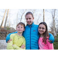 three kids smiling together for a photo