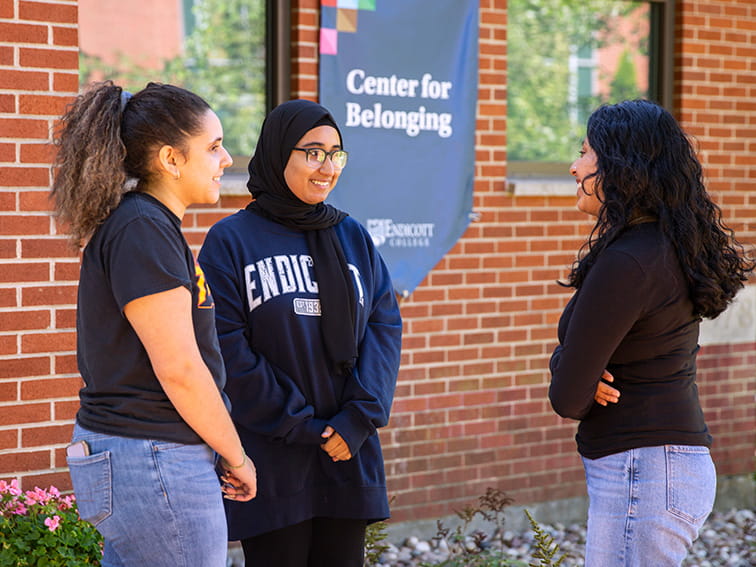 Three women standing by the Center for Belonging at Endicott College