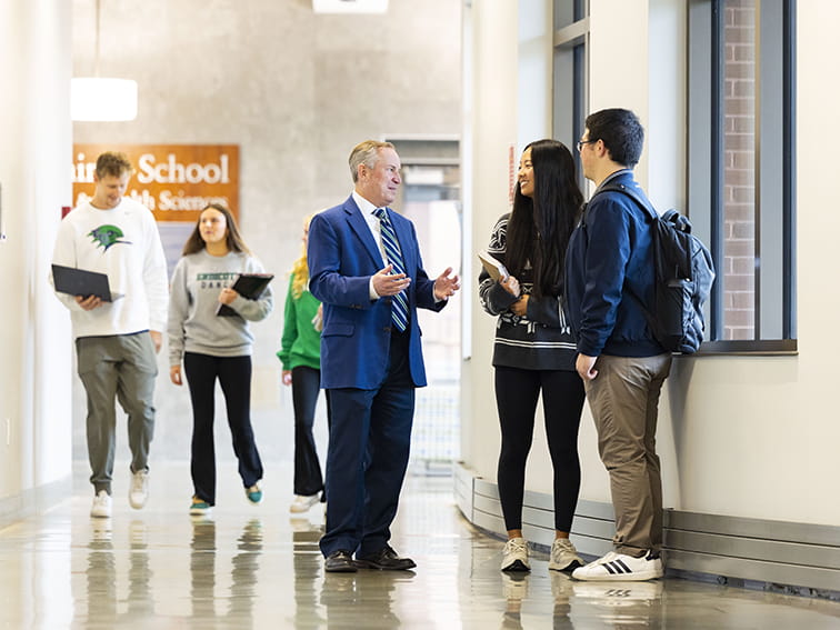 President DiSalvo talking with students in a hallway
