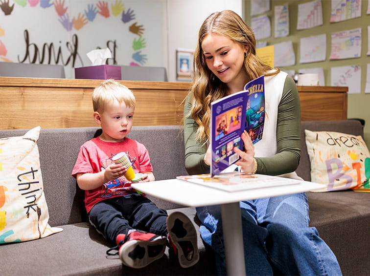 Student reading a book to a child