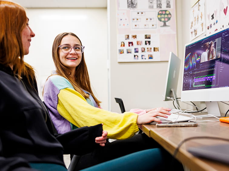 Students talking in front of a computer