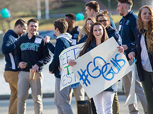 a group of students cheering and holding up signs in support of the gulls