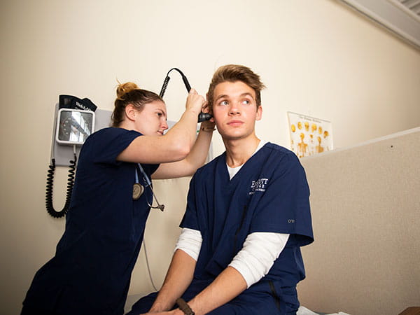 Female student nurse evaluating a male student subject