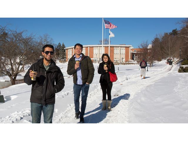 Three Endicott students walking from the academic center in the snow