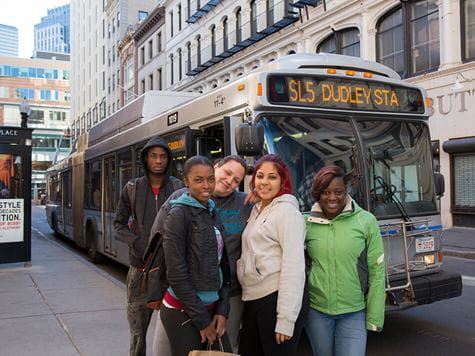 students in boston in front of city bus